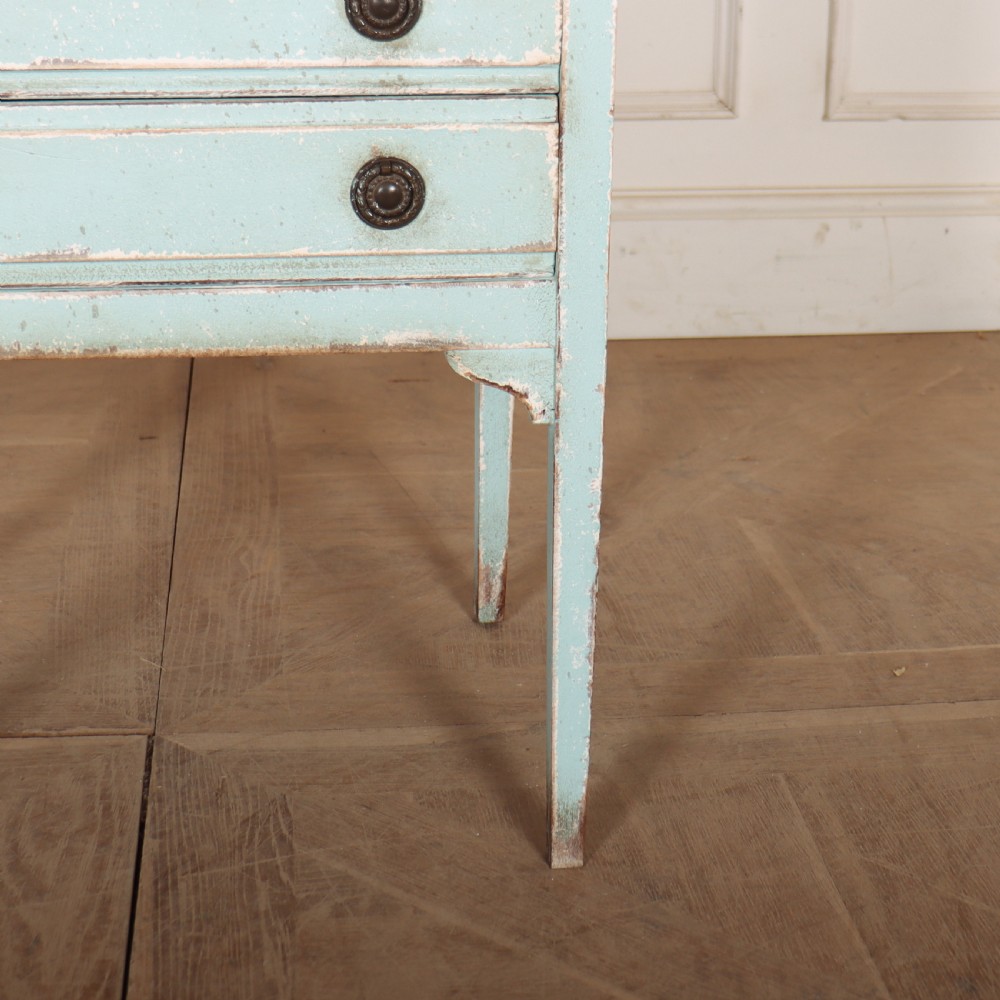 A pale blue painted three-drawer antique bedside cabinet featuring dark round knobs and a low gallery top. View IV