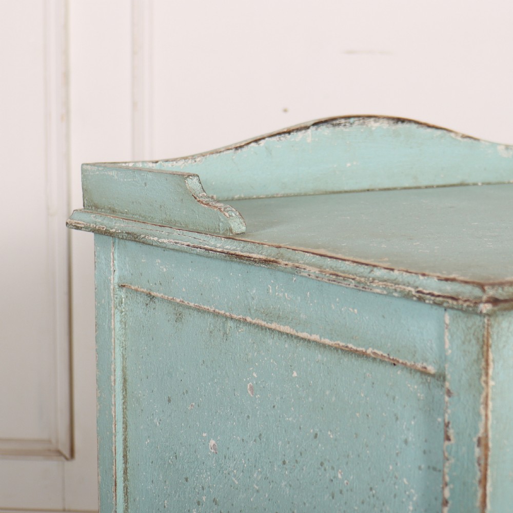 A pale blue painted three-drawer antique bedside cabinet featuring dark round knobs and a low gallery top. View VII
