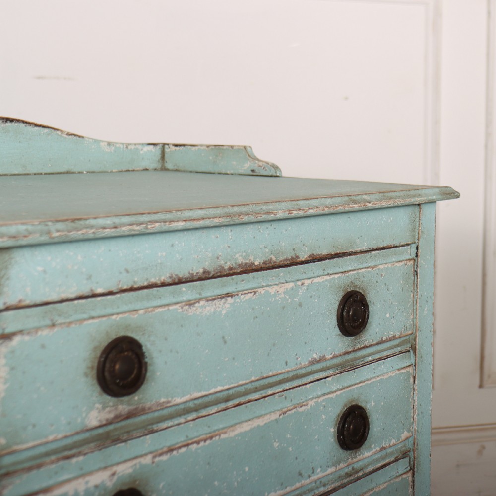 A pale blue painted three-drawer antique bedside cabinet featuring dark round knobs and a low gallery top. View VIII