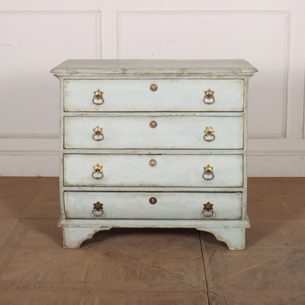 A nineteenth-century Dutch four-drawer commode featuring a distressed pale blue painted finish, brass rosette ring handles, and bracket feet.