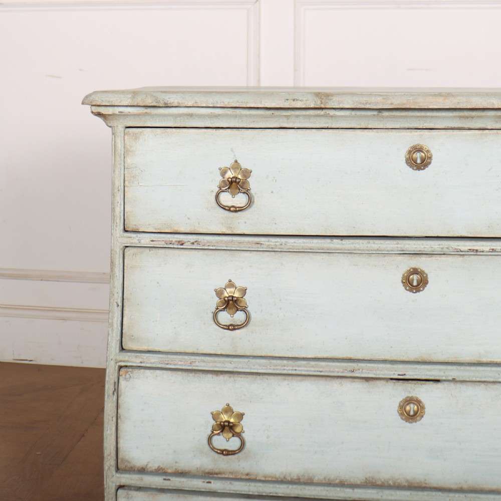 A nineteenth-century Dutch four-drawer commode featuring a distressed pale blue painted finish, brass rosette ring handles, and bracket feet. View II