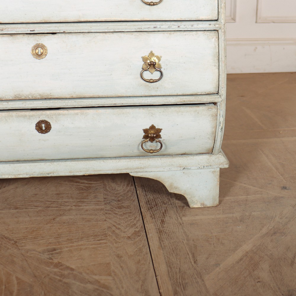 A nineteenth-century Dutch four-drawer commode featuring a distressed pale blue painted finish, brass rosette ring handles, and bracket feet. View V
