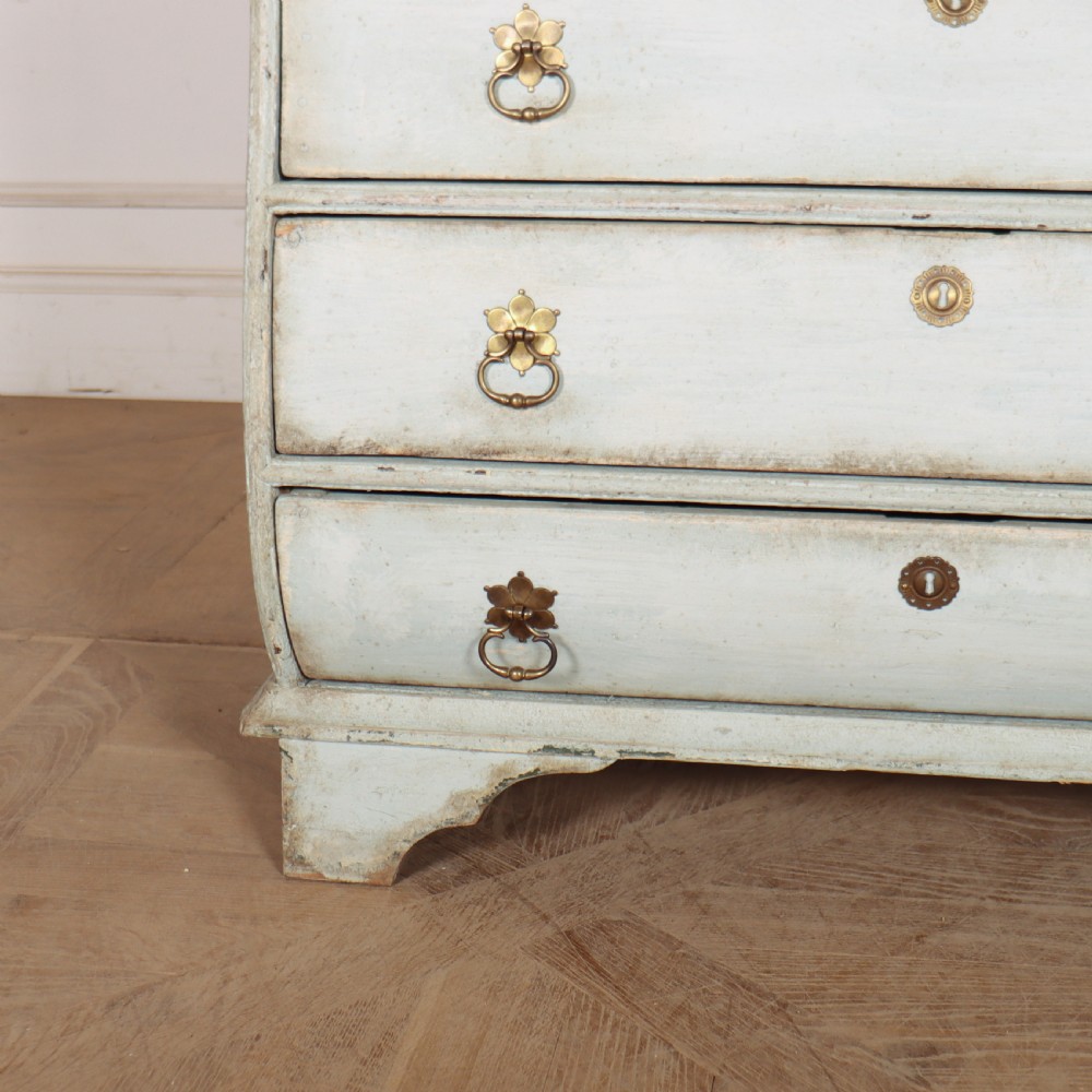 A nineteenth-century Dutch four-drawer commode featuring a distressed pale blue painted finish, brass rosette ring handles, and bracket feet. View VI