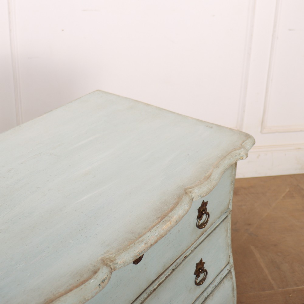 A nineteenth-century Dutch four-drawer commode featuring a distressed pale blue painted finish, brass rosette ring handles, and bracket feet. View X