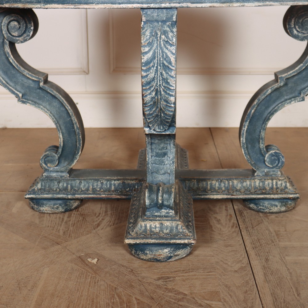 A round blue painted lamp table featuring a starburst pattern top, carved scroll legs, and an X-frame base. View II