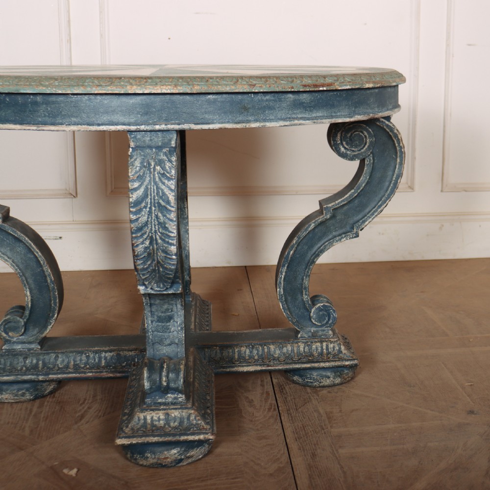A round blue painted lamp table featuring a starburst pattern top, carved scroll legs, and an X-frame base. View III