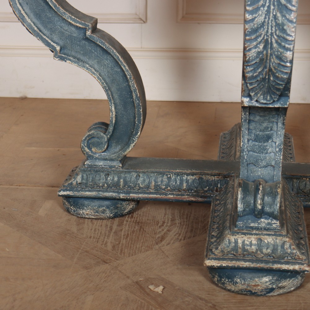 A round blue painted lamp table featuring a starburst pattern top, carved scroll legs, and an X-frame base. View VI
