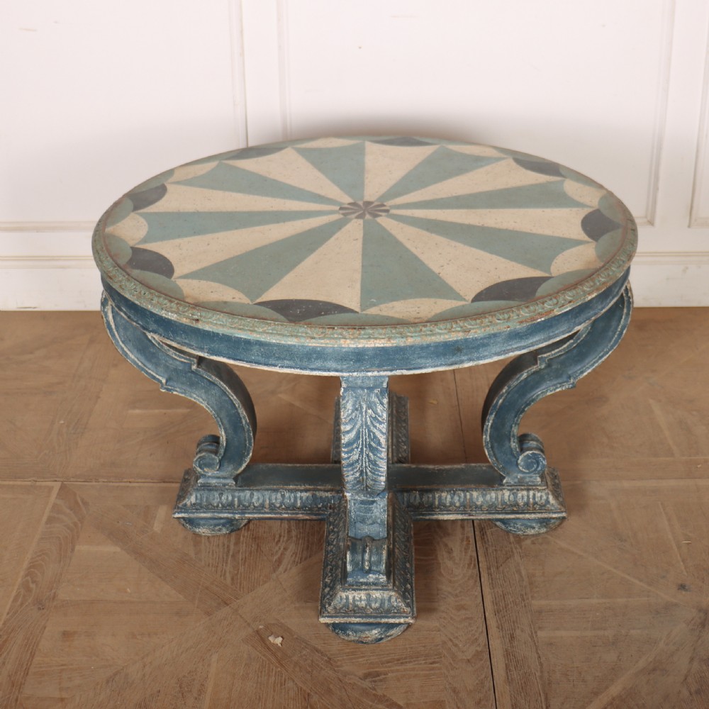A round blue painted lamp table featuring a starburst pattern top, carved scroll legs, and an X-frame base. View VIII