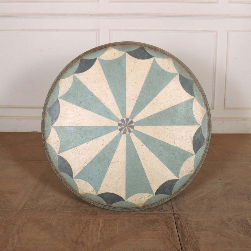 A round blue painted lamp table featuring a starburst pattern top, carved scroll legs, and an X-frame base. View IX