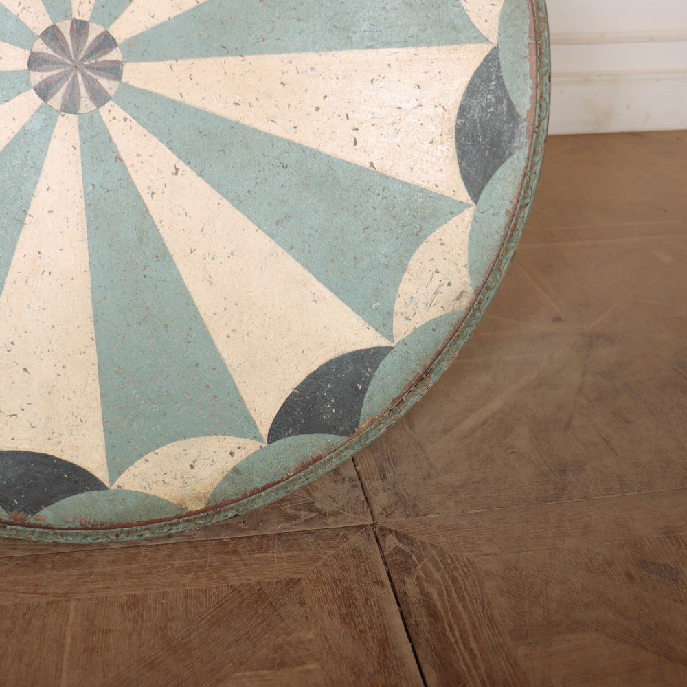 A round blue painted lamp table featuring a starburst pattern top, carved scroll legs, and an X-frame base. View XIII