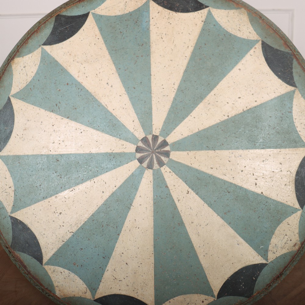 A round blue painted lamp table featuring a starburst pattern top, carved scroll legs, and an X-frame base. View XIV