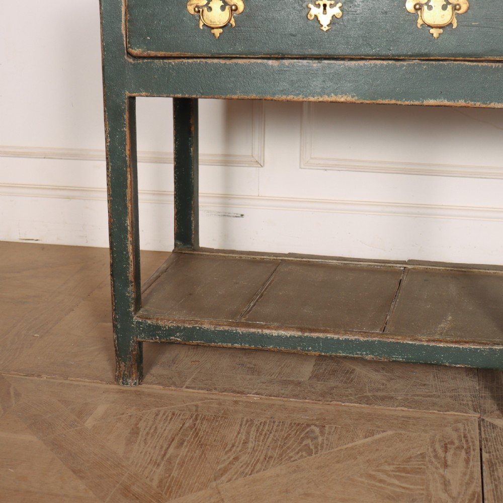 An antique dark green painted wooden pot board dresser featuring an upper three-tier plate rack with cup hooks above two drawers and an open bottom shelf. View III