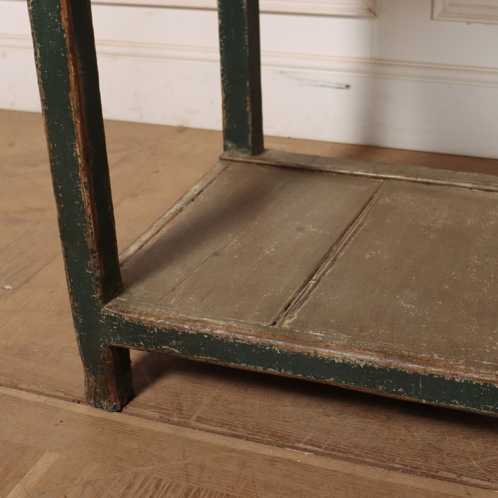 An antique dark green painted wooden pot board dresser featuring an upper three-tier plate rack with cup hooks above two drawers and an open bottom shelf. View XII