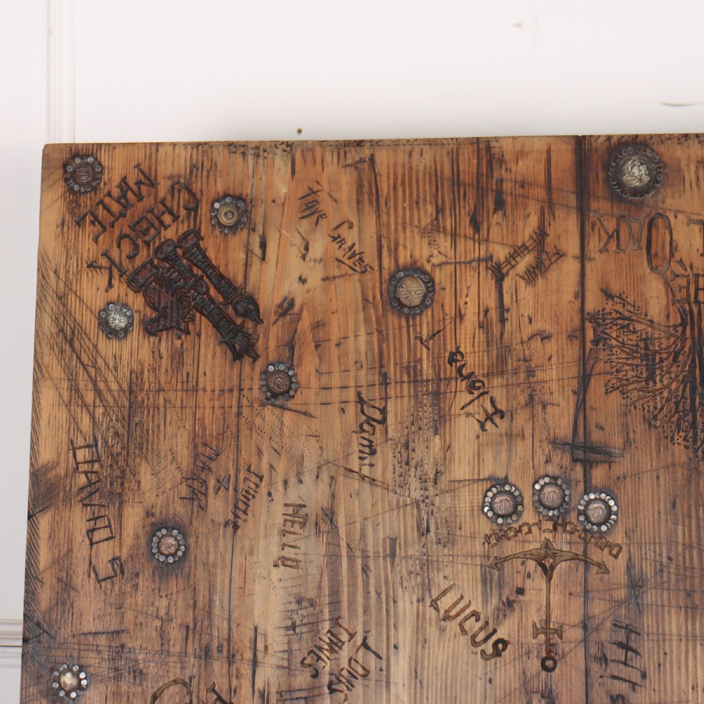 A low rectangular wooden coffee table featuring turned reeded legs and a surface decorated with carved typography and circular details. View VIII