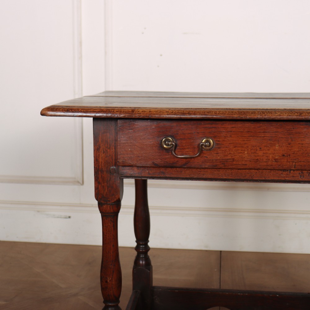 An antique English oak lamp table featuring a single drawer with brass handles, turned legs, and lower stretchers. View II