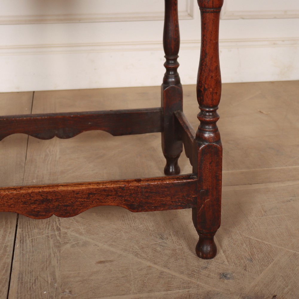 An antique English oak lamp table featuring a single drawer with brass handles, turned legs, and lower stretchers. View IV