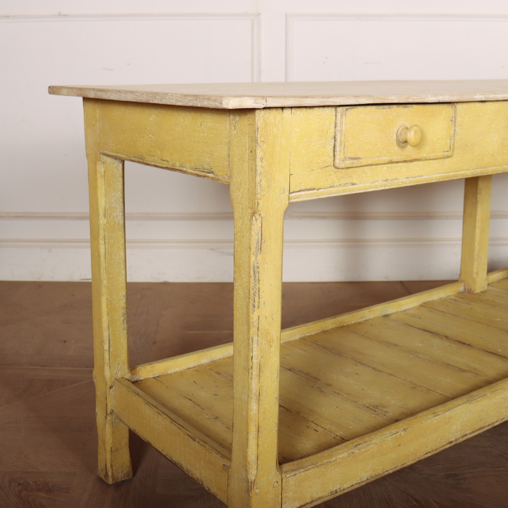 A long antique English painted wooden serving table featuring five drawers, a natural timber top, a distressed yellow base, and a low potboard shelf. View II