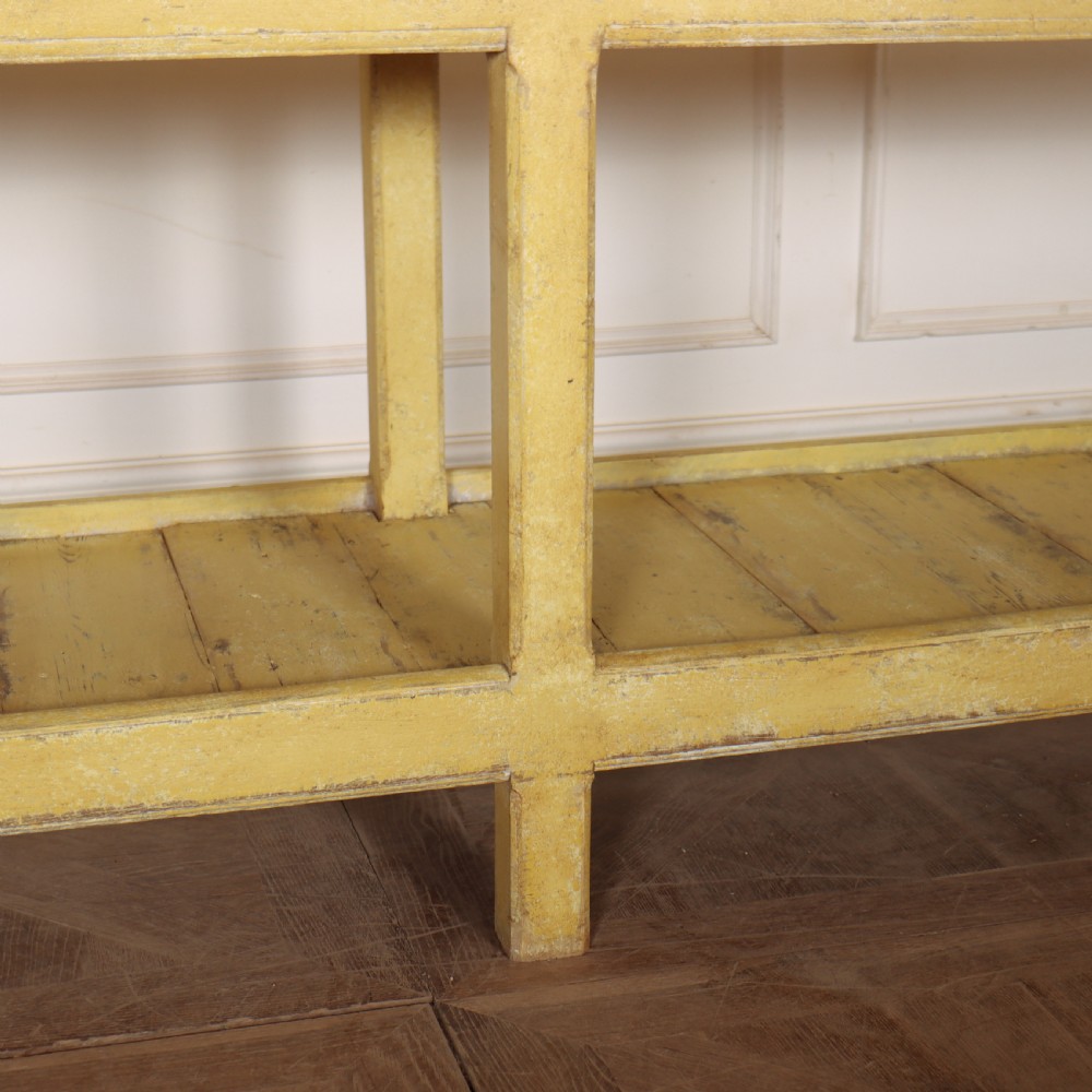 A long antique English painted wooden serving table featuring five drawers, a natural timber top, a distressed yellow base, and a low potboard shelf. View VIII