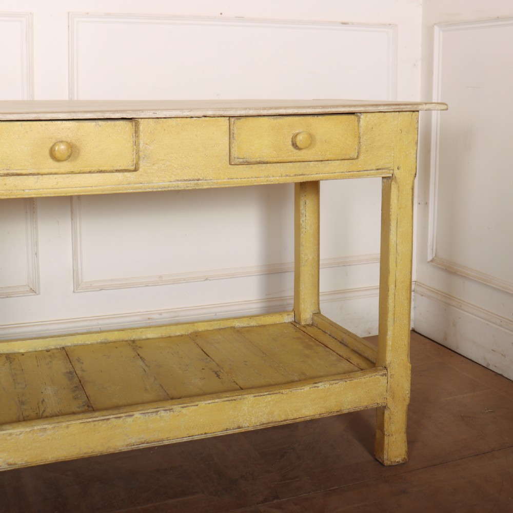 A long antique English painted wooden serving table featuring five drawers, a natural timber top, a distressed yellow base, and a low potboard shelf. View IX