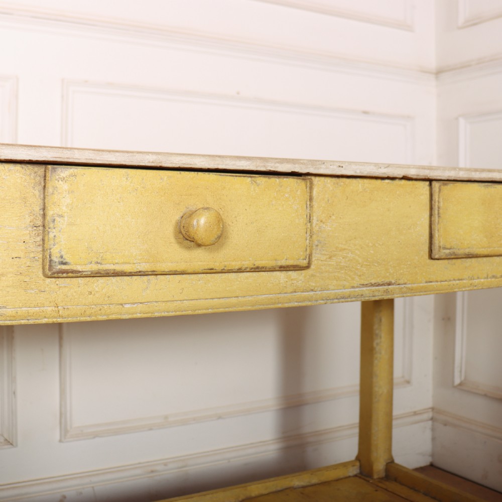 A long antique English painted wooden serving table featuring five drawers, a natural timber top, a distressed yellow base, and a low potboard shelf. View XIII