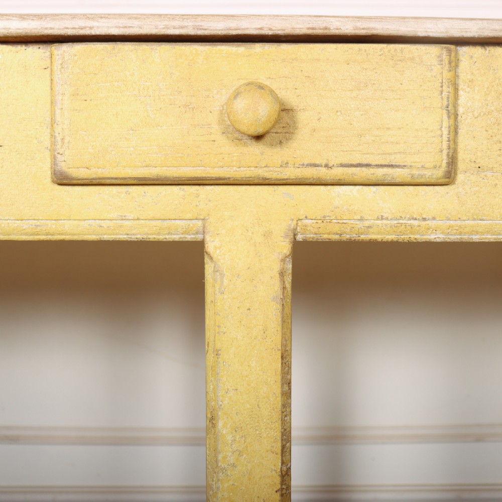 A long antique English painted wooden serving table featuring five drawers, a natural timber top, a distressed yellow base, and a low potboard shelf. View XV