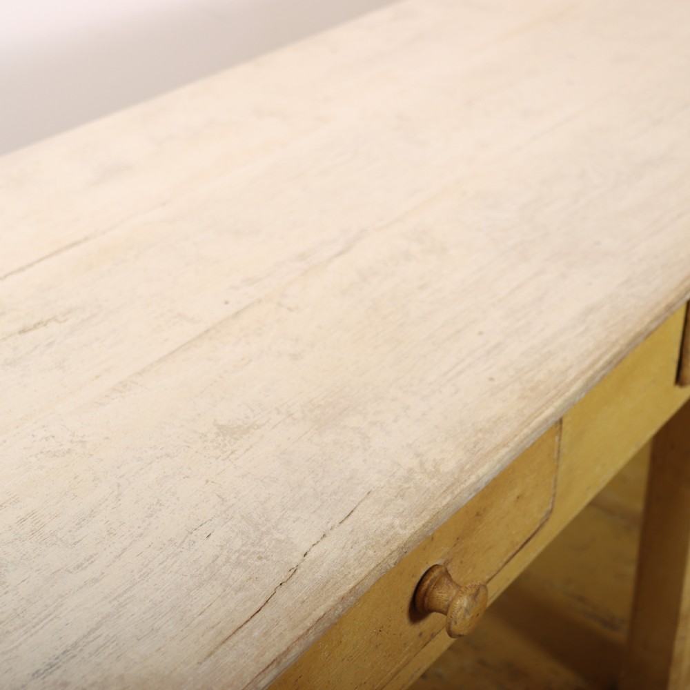 A long antique English painted wooden serving table featuring five drawers, a natural timber top, a distressed yellow base, and a low potboard shelf. View XVIII