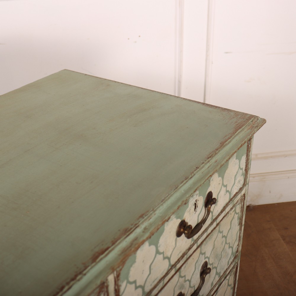 A two-over-three antique English chest of drawers painted in sage green with off-white quatrefoil patterned drawer fronts and brass handles. View XI
