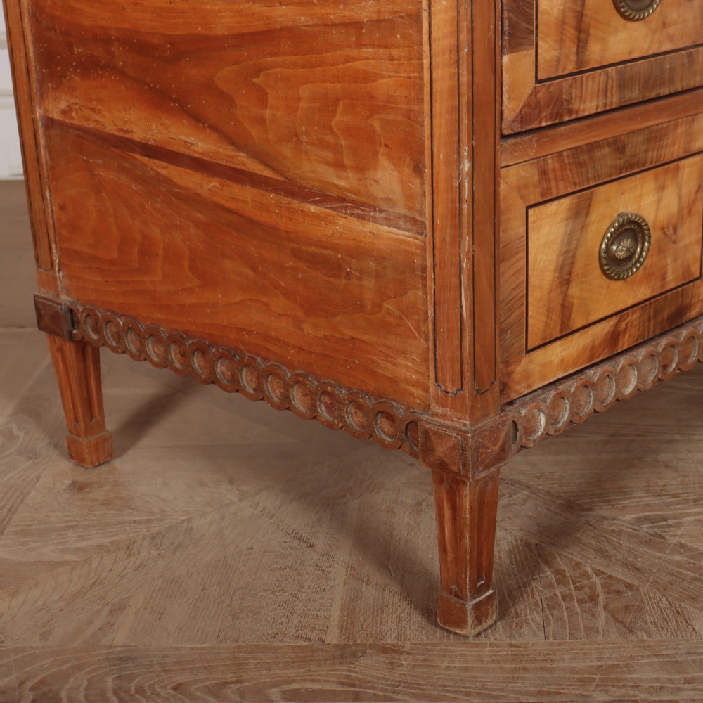An antique Austrian walnut breakfront commode with three central drawers flanked by panels, decorated with geometric veneers and oval brass handles. View IX