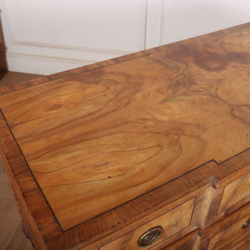 An antique Austrian walnut breakfront commode with three central drawers flanked by panels, decorated with geometric veneers and oval brass handles. View XI