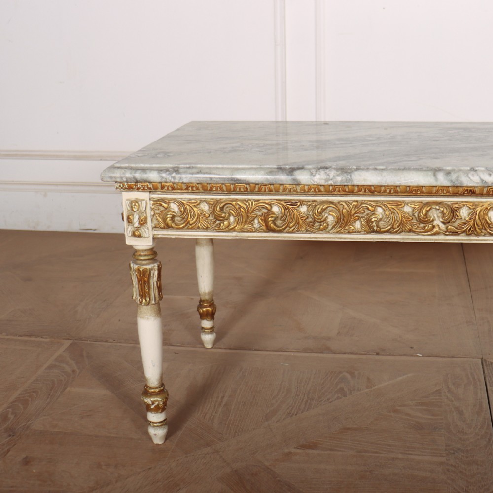 A rectangular French Louis XVI style low coffee table featuring a grey and white veined marble top set on a carved giltwood and painted frame with fluted tapered legs. View VIII