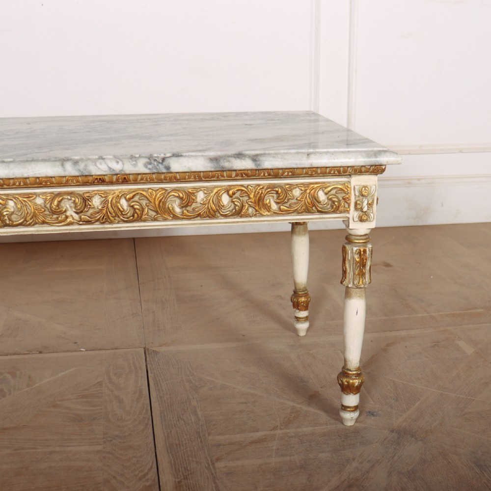 A rectangular French Louis XVI style low coffee table featuring a grey and white veined marble top set on a carved giltwood and painted frame with fluted tapered legs. View IX