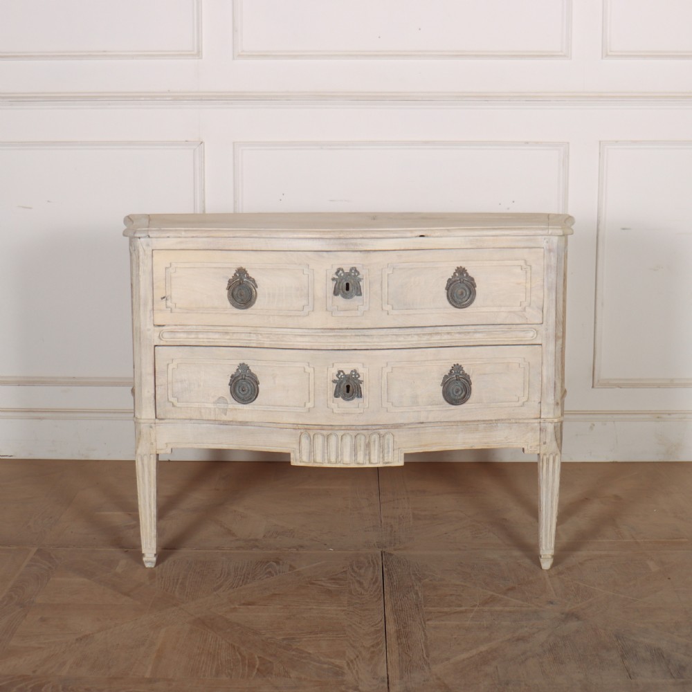 An off-white painted Italian serpentine front commode with two long drawers, panel moulding, metal handles, and square tapered legs.