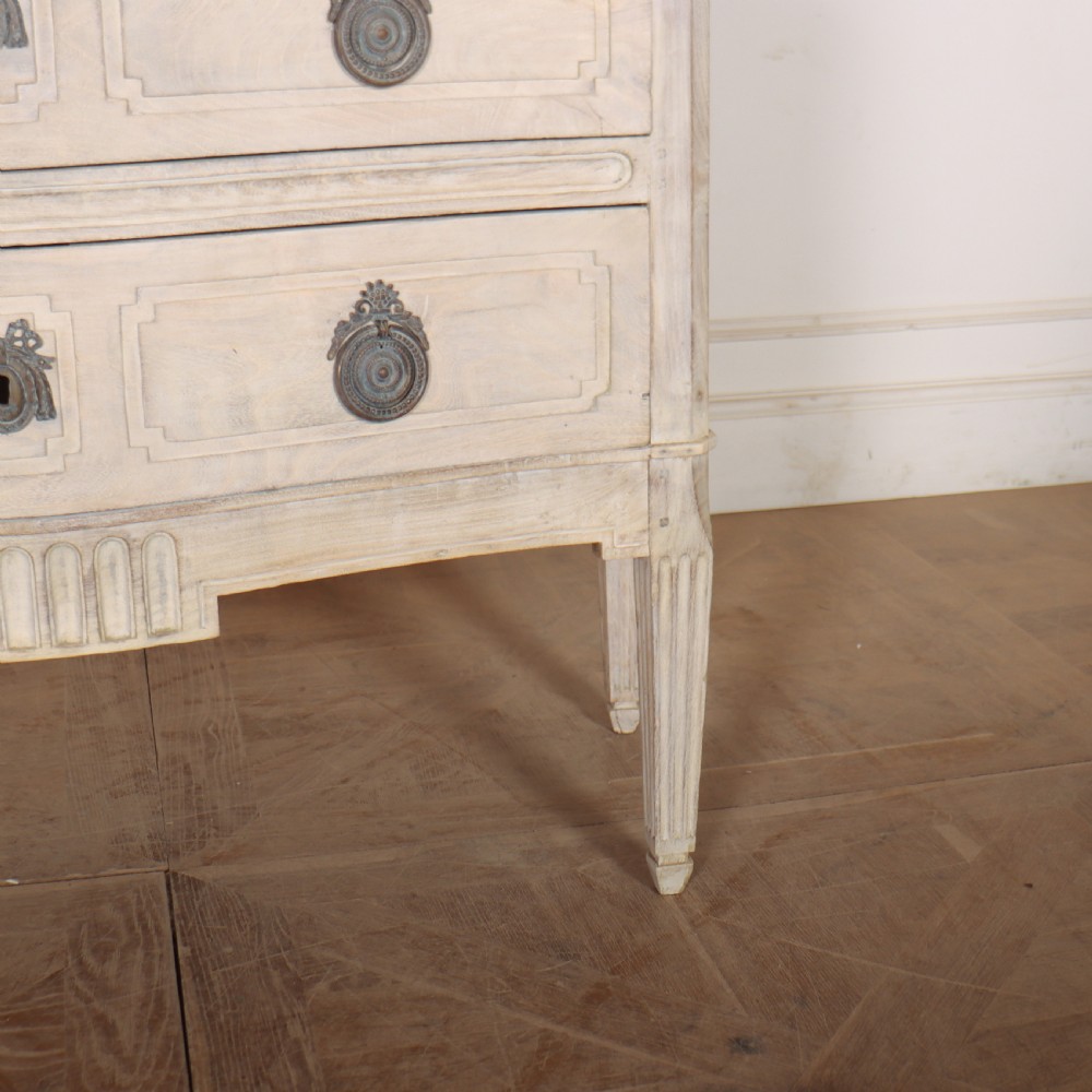 An off-white painted Italian serpentine front commode with two long drawers, panel moulding, metal handles, and square tapered legs. View III