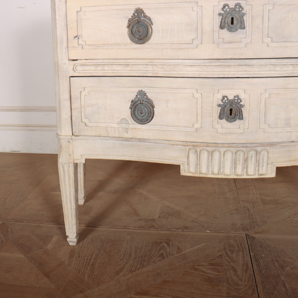 An off-white painted Italian serpentine front commode with two long drawers, panel moulding, metal handles, and square tapered legs. View VI