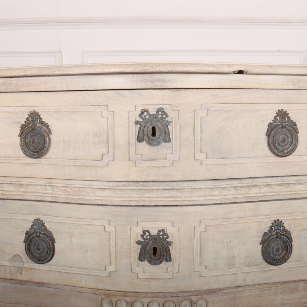 An off-white painted Italian serpentine front commode with two long drawers, panel moulding, metal handles, and square tapered legs. View VII
