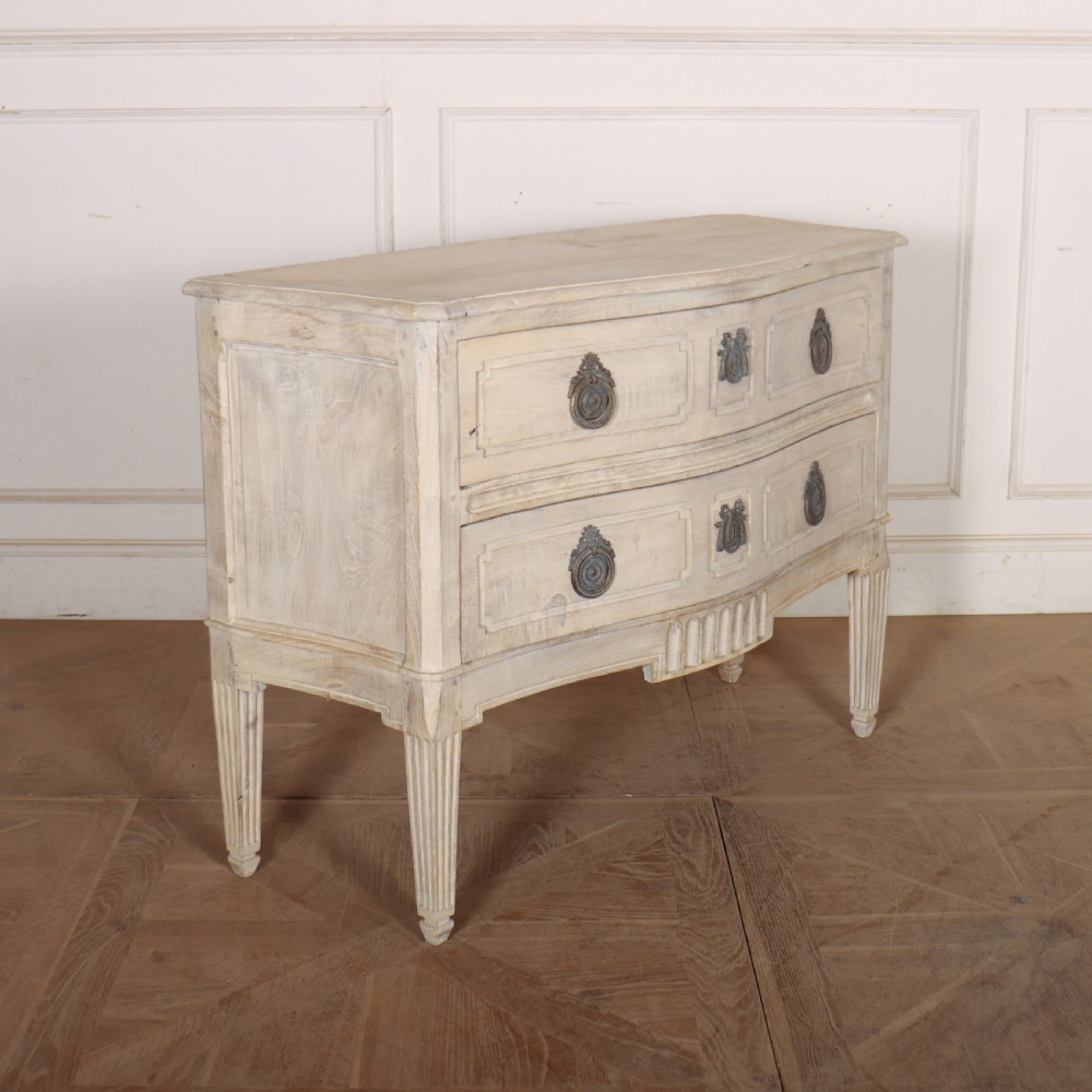 An off-white painted Italian serpentine front commode with two long drawers, panel moulding, metal handles, and square tapered legs. View IX