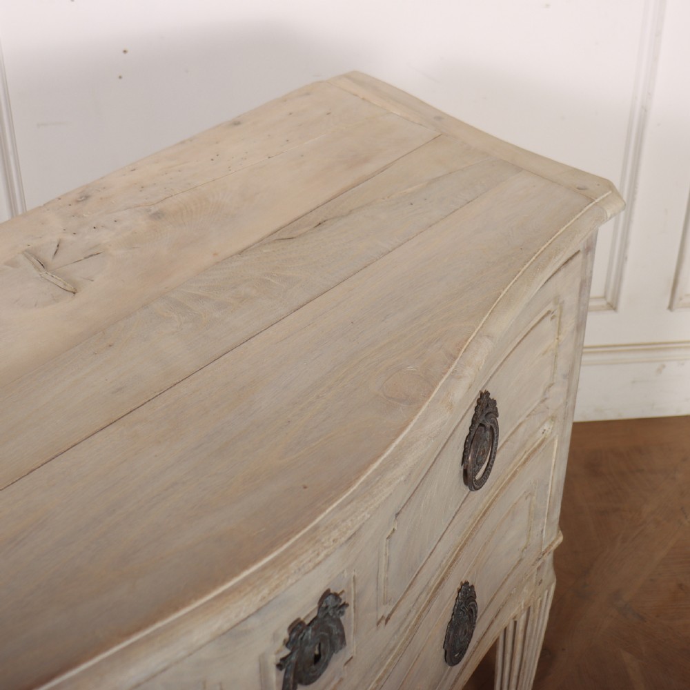 An off-white painted Italian serpentine front commode with two long drawers, panel moulding, metal handles, and square tapered legs. View XI