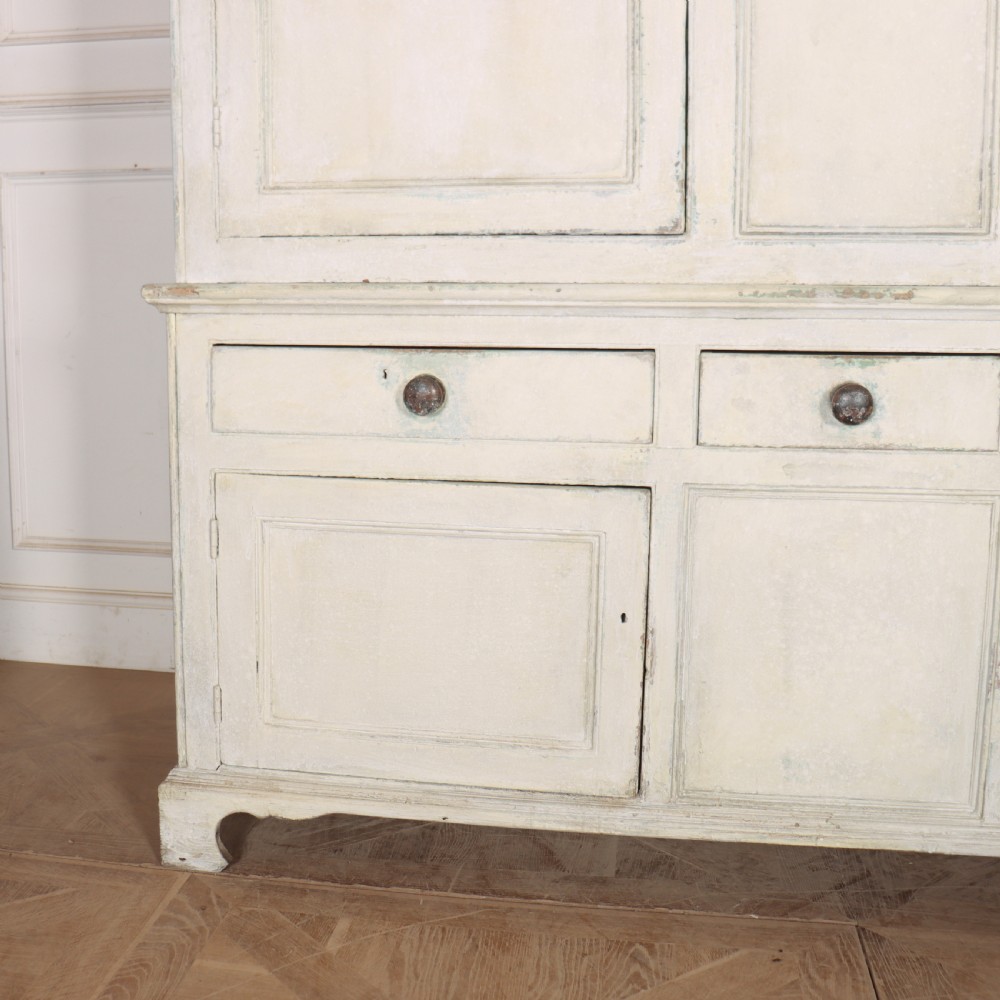 An 18th-century painted housekeepers cupboard featuring fielded panel upper doors, three central drawers, and lower storage cabinets on bracket feet. View III