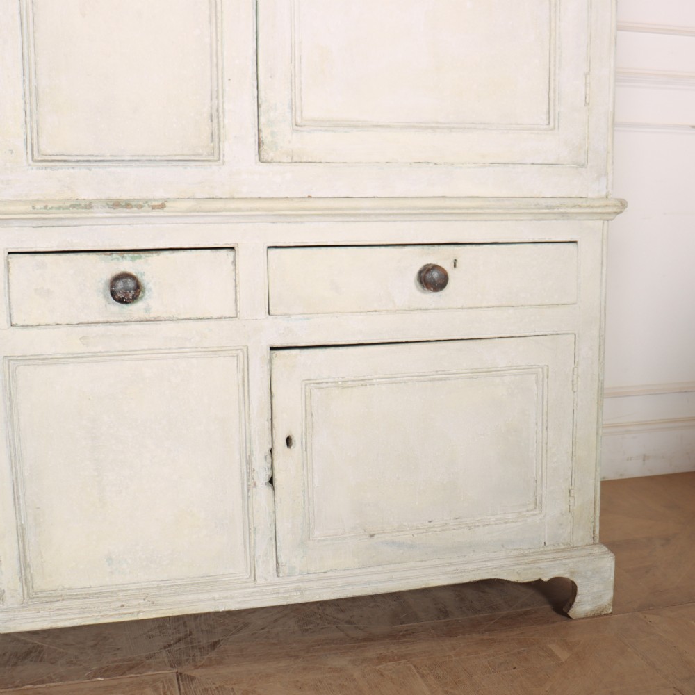 An 18th-century painted housekeepers cupboard featuring fielded panel upper doors, three central drawers, and lower storage cabinets on bracket feet. View IV