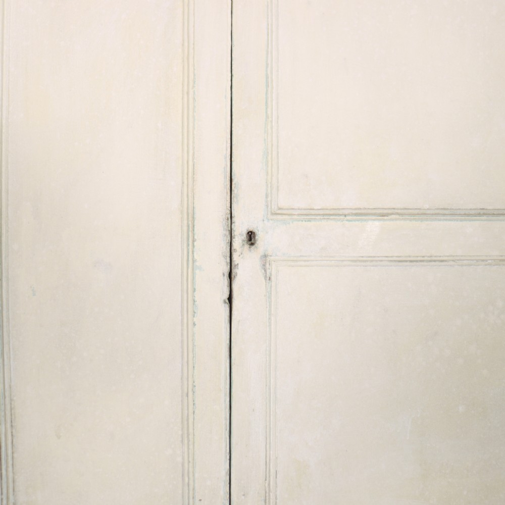 An 18th-century painted housekeepers cupboard featuring fielded panel upper doors, three central drawers, and lower storage cabinets on bracket feet. View V