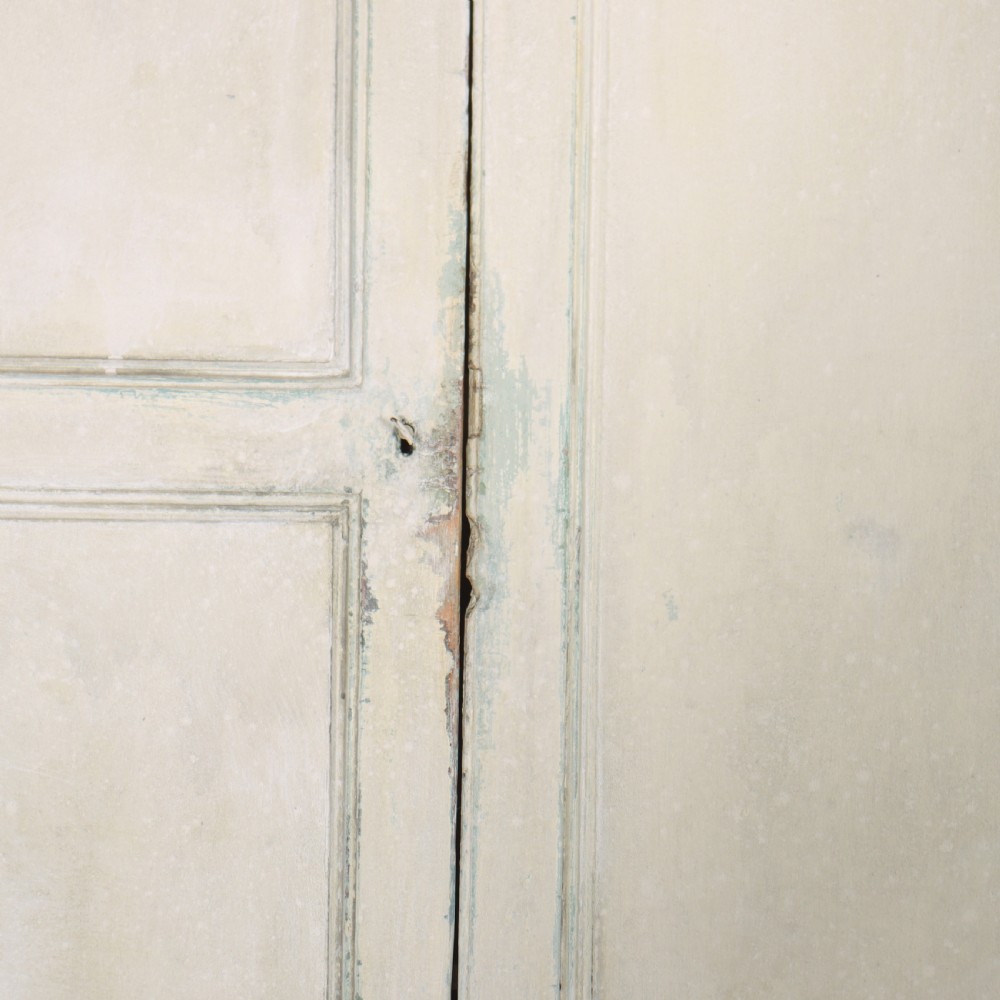 An 18th-century painted housekeepers cupboard featuring fielded panel upper doors, three central drawers, and lower storage cabinets on bracket feet. View VII