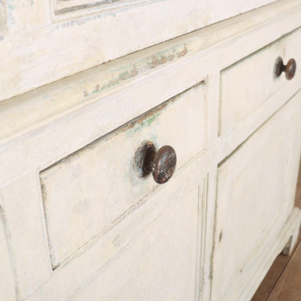 An 18th-century painted housekeepers cupboard featuring fielded panel upper doors, three central drawers, and lower storage cabinets on bracket feet. View VIII