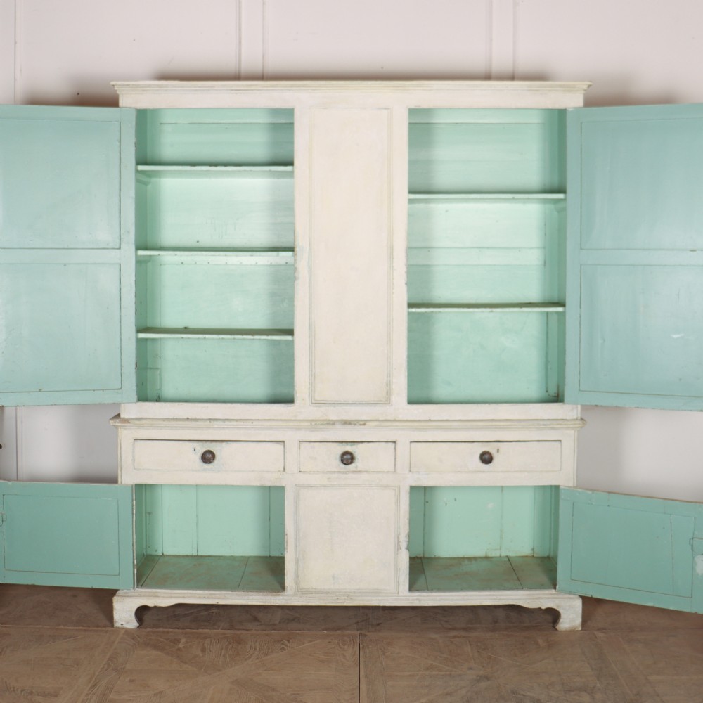 An 18th-century painted housekeepers cupboard featuring fielded panel upper doors, three central drawers, and lower storage cabinets on bracket feet. View IX