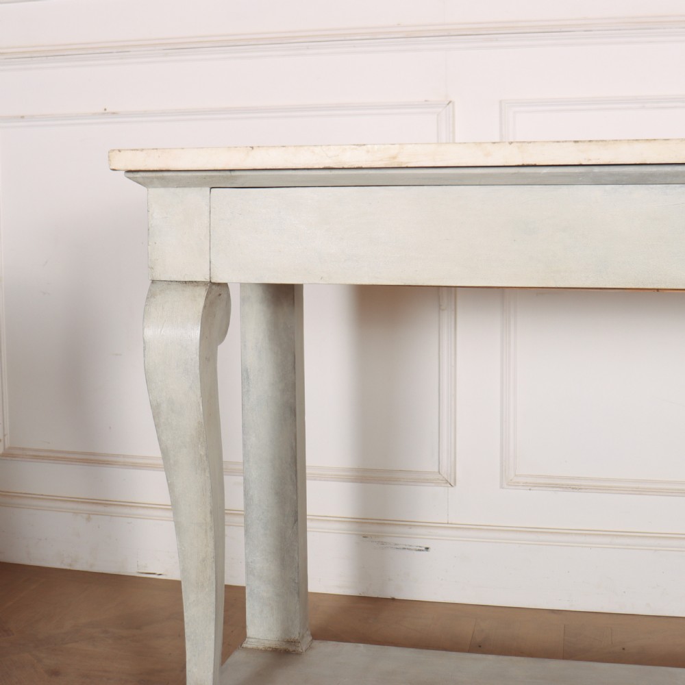 A pale grey painted French console table featuring a light marble top slab, cabriole front legs, and a bottom plinth shelf. View III
