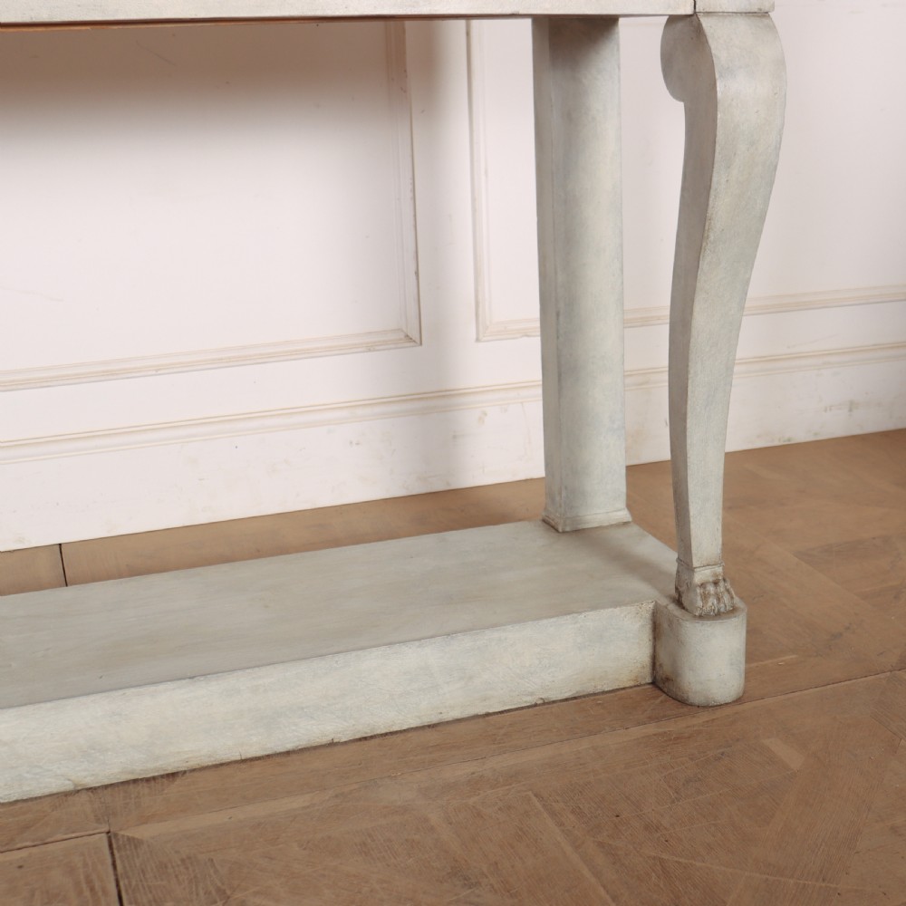 A pale grey painted French console table featuring a light marble top slab, cabriole front legs, and a bottom plinth shelf. View V