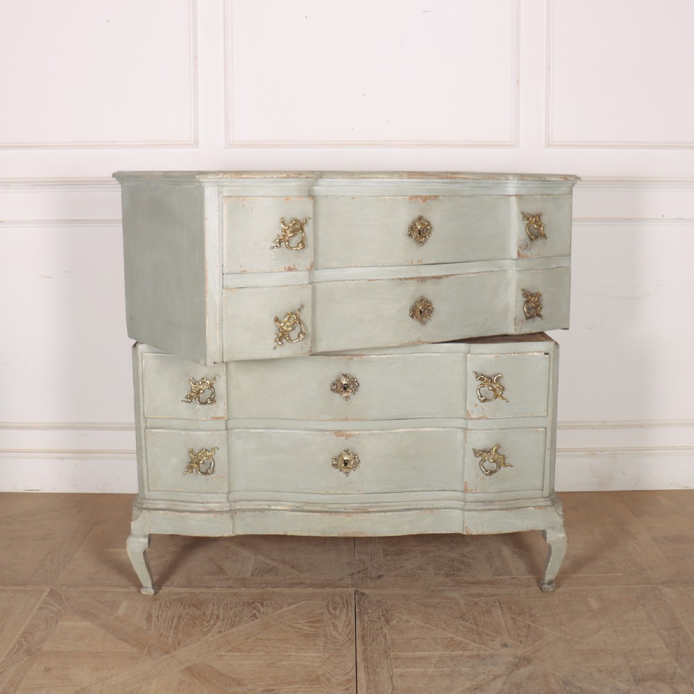 A four-drawer painted Danish serpentine front commode featuring ornate brass drop handles, keyhole escutcheons, and short cabriole legs. View X