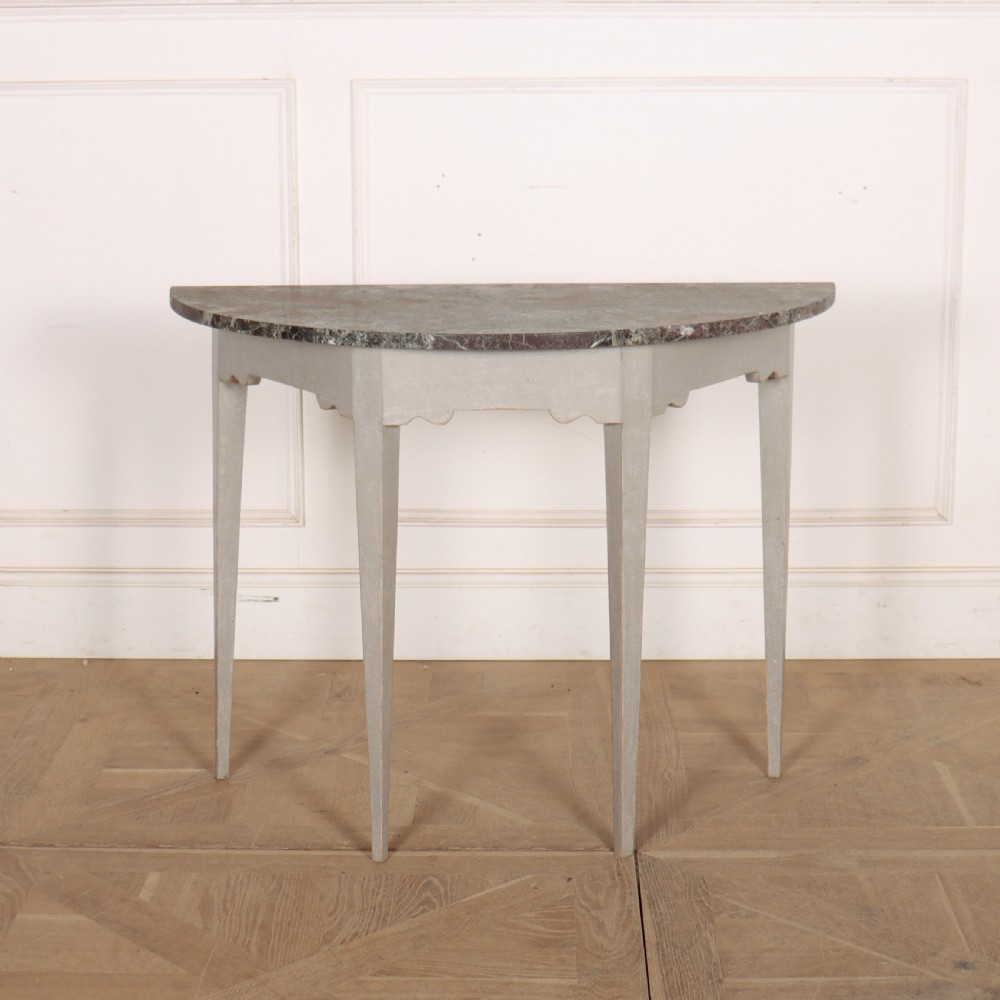 A 19th-century demilune console table featuring a grey marble top and a light grey painted frame supported by four tapered square legs.
