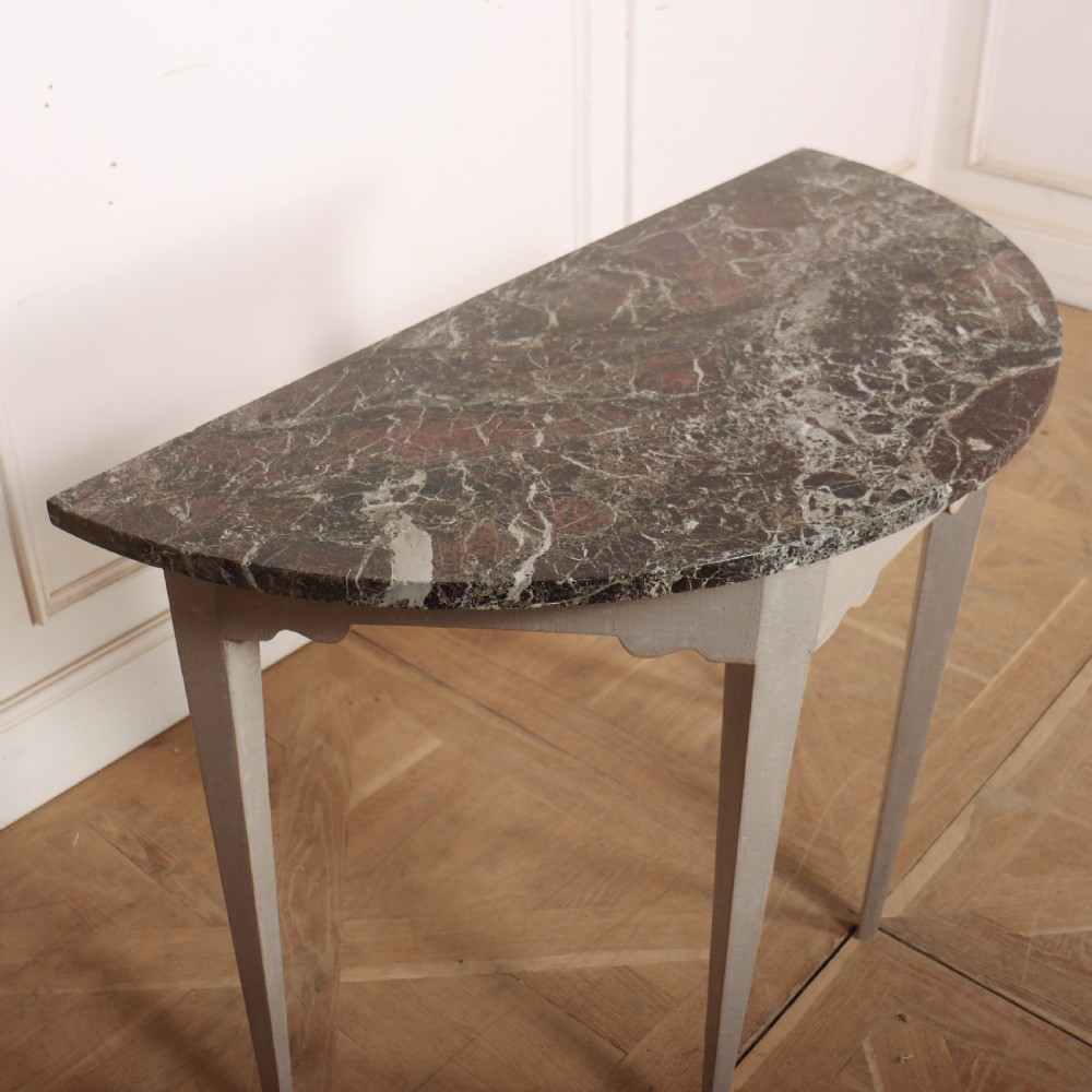 A 19th-century demilune console table featuring a grey marble top and a light grey painted frame supported by four tapered square legs. View V