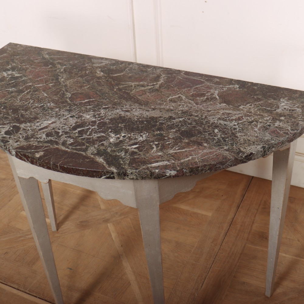 A 19th-century demilune console table featuring a grey marble top and a light grey painted frame supported by four tapered square legs. View VI