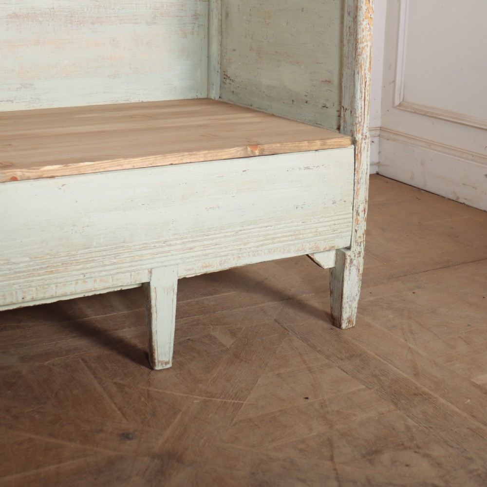 A pale green painted Swedish wooden bench featuring a shaped crest rail, panelled sides, and a natural pine seat. View IV